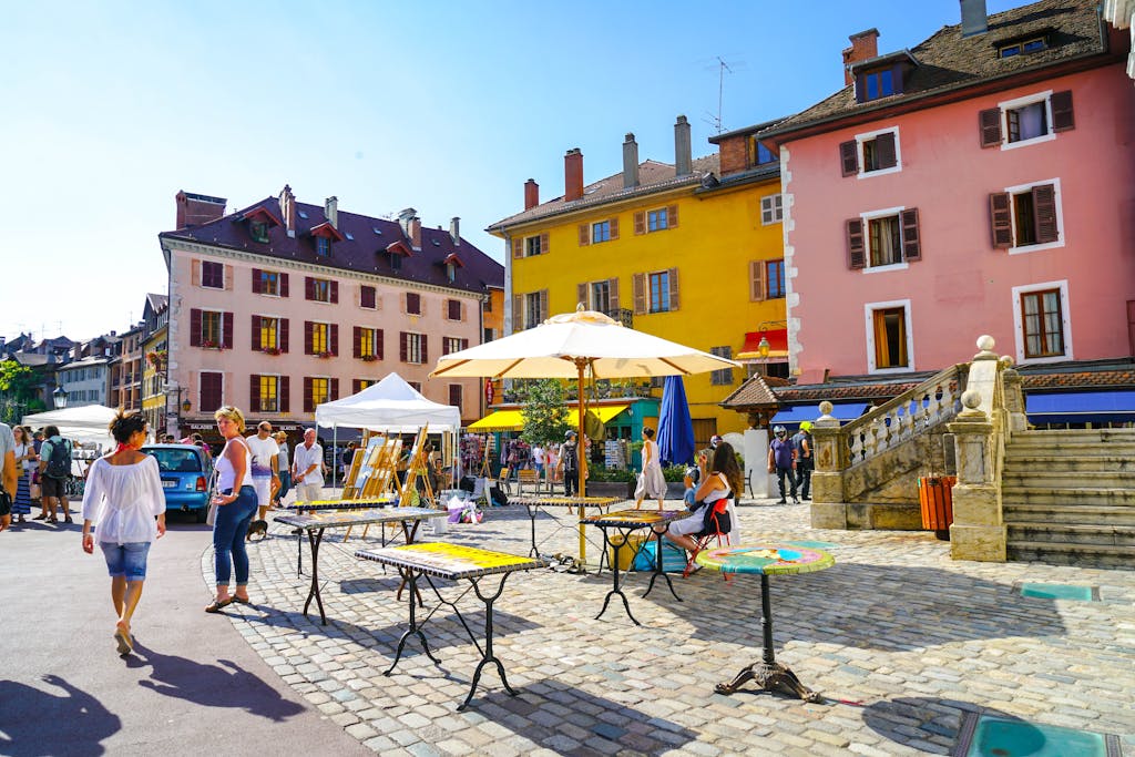 Charming marketplace in Annecy, France with bright buildings and lively street life.
