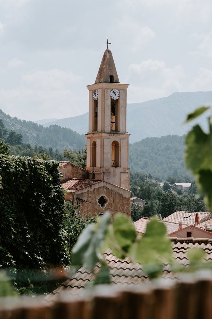 Discover the picturesque church tower of Ucciani village in Corsica, France, surrounded by lush greenery.