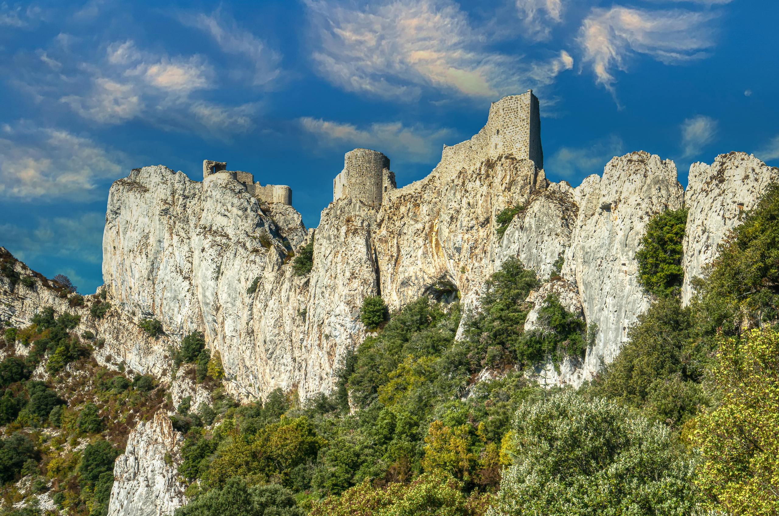 Explore the medieval Peyrepertuse Castle perched on limestone cliffs in a stunning French landscape.